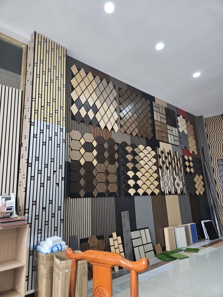 A showroom wall covered in slatted acoustic wall panels and patterned acoustic tiles in oak, walnut, black, gold and silver finishes