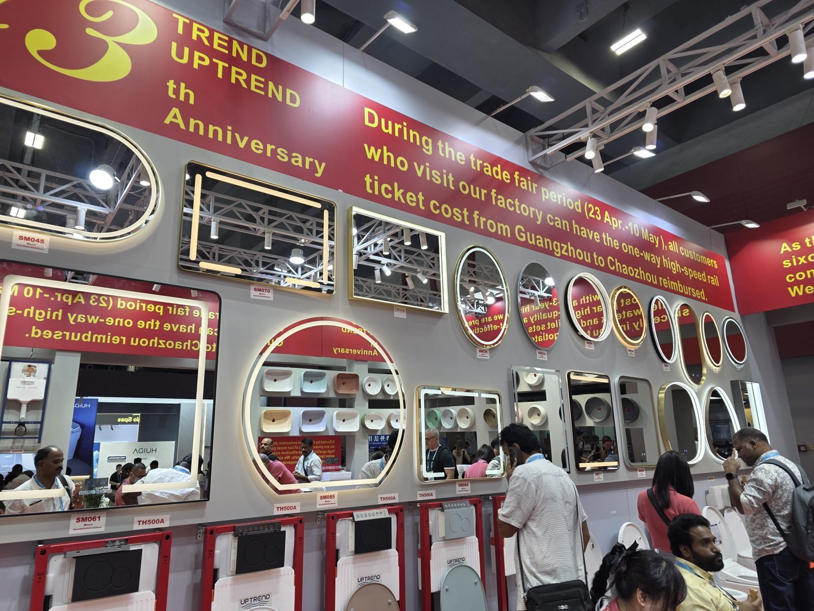 A wall of LED-lit bathroom mirrors and in-wall toilet cisterns at a Canton Fair booth