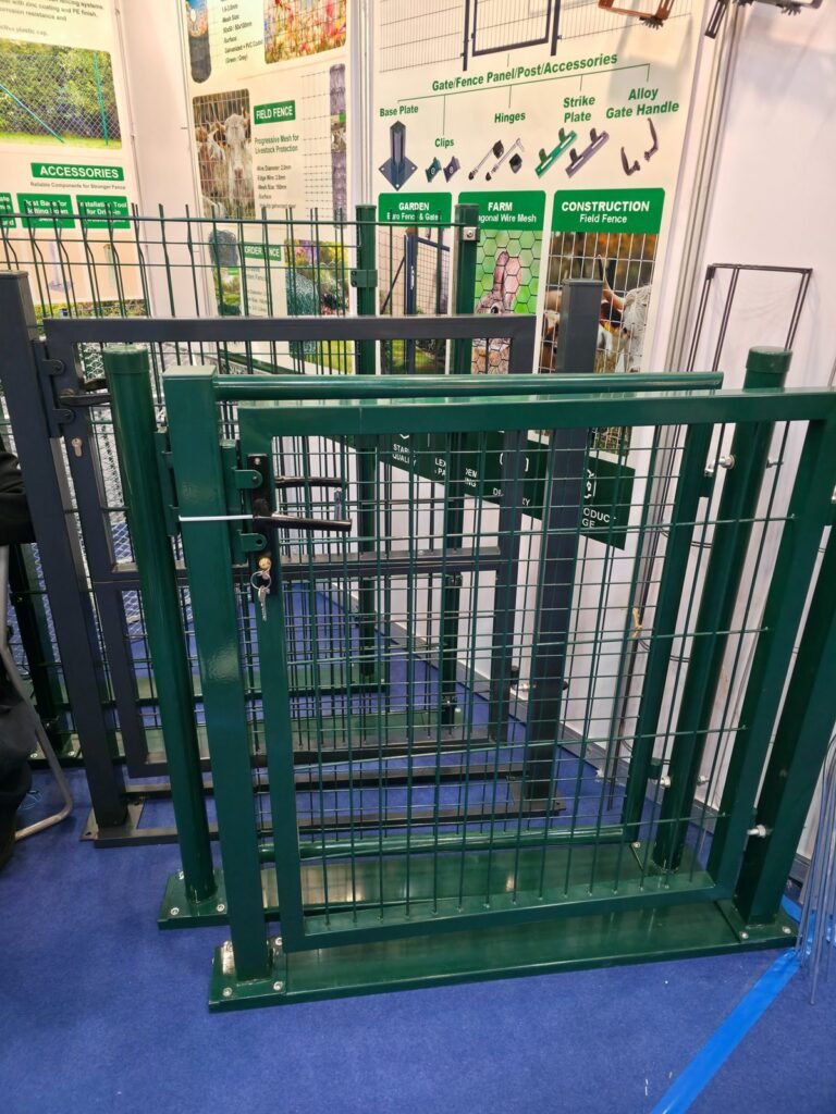 Green and grey powder-coated welded mesh fence panels, gates and posts with fence accessories on display at a Canton Fair fencing booth