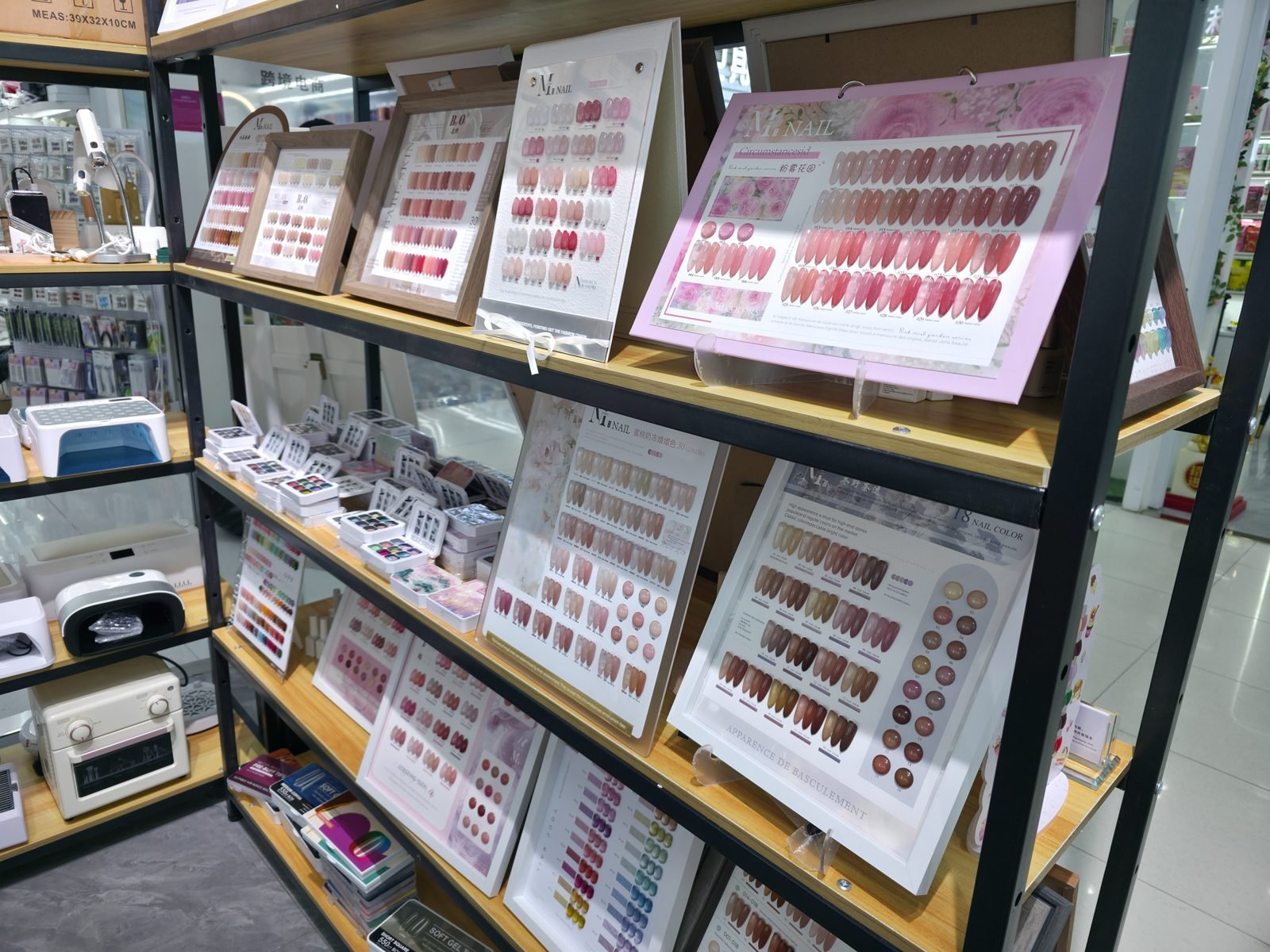 Shelves of nail gel colour charts and UV nail lamps at a beauty supplies wholesaler in China